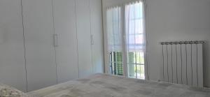Un dormitorio con una cama y una ventana grande. en Villa Rocca - mansarda, en Borgio Verezzi