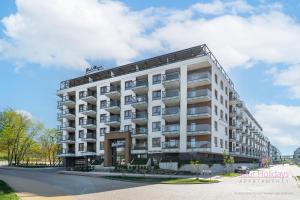 a large white building on the side of a street at Your Holidays Bel Mare Aqua F203 in Międzyzdroje