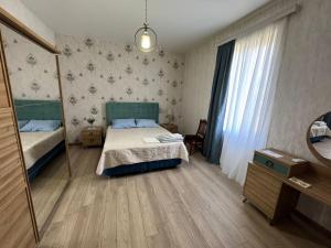 a small bedroom with a bed and a mirror at Dadu's Guesthouse in Samtredia