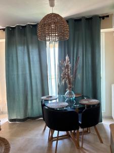 a dining room with a table and chairs and a window at Bleu Azur -Vue Mer 6e Etage - Triangle d'Or in Saint-Raphaël