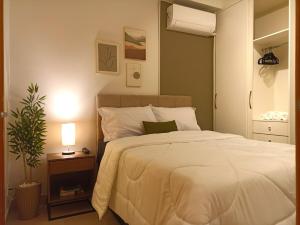 a bedroom with a bed and a night stand with a plant at Apê super charmoso! Ar-condicionado e piscina in Brasilia