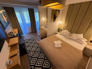 a bedroom with a bed with two towels on it at Alpin Vista in Buşteni