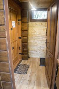 a hallway of a tiny house with a door and a rug at A fák ölelése vendégház in Bükkaranyos