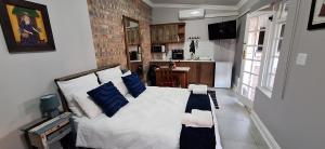 Un dormitorio con una cama blanca con almohadas azules. en Firehouse guest suite no 3, en Wellington