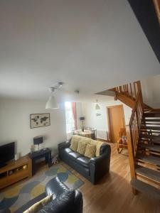 a living room with a leather couch and a television at Portstewart Escape in Portstewart