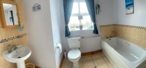 a bathroom with a toilet and a sink and a tub at Portstewart Escape in Portstewart +13 photos