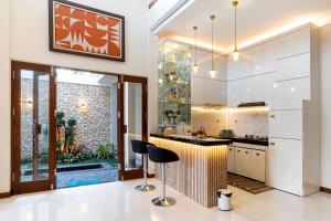 a kitchen with a counter and a bar with a stool at Griya Genitri in Malang