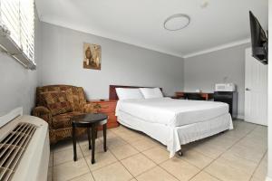 a hotel room with a bed and a chair at iCheck Inn Motel Windsor in Windsor
