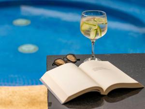 an open book and a glass of wine and a drink at Hotel Alma in Villa de Leyva