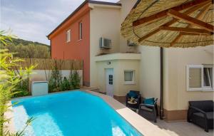 a swimming pool in the backyard of a house with an umbrella at Awesome Home In Miholascica in Miholašćica