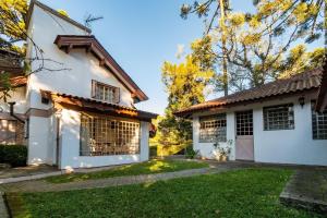 an exterior view of a white house at Rosa Casa Jardim da Serra in Canela
