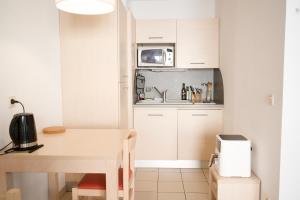 a small kitchen with a table and a microwave at Studio climatisé à Divonne-les-Bains in Divonne-les-Bains