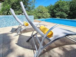 a reclining chair next to a swimming pool at Casa com piscina privada e jacuzzi no Gerês in Pandoses