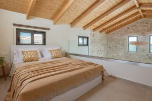 a bedroom with a large bed and a stone wall at Petra Natura Villa in Zakynthos Town +62 photos