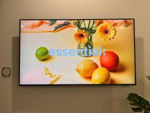 a television screen with fruit and a vase with flowers at Vinhomes Grand Park Homestay-The Beverly Hills in Long Bình