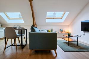 - un salon avec des lucarnes, un canapé et une table dans l'établissement Le Boulonnais - Les Demeures d'Adrien, à Boulogne-sur-Mer