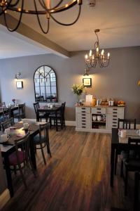 a dining room with tables and chairs and a chandelier at Skyline Guesthouse Newquay in Newquay