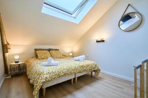 une chambre avec un lit et une lucarne dans l'établissement Le Boulonnais - Les Demeures d'Adrien, à Boulogne-sur-Mer