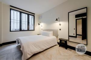 Un dormitorio con una gran cama blanca y un espejo. en Un Madrid moderno para 7, tu refugio en Abada 2 E2, en Madrid