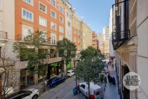 una calle de la ciudad con coches y edificios aparcados en Un Madrid moderno para 7, tu refugio en Abada 2 E2, en Madrid