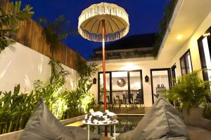 a living room with a table with a umbrella at Villa Mimoza Umalas Bali in Kerobokan