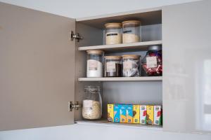 a kitchen pantry door open with jars of food at Apartment - Sleeps 2 - Parking - Great Location in Isleworth +4 photos