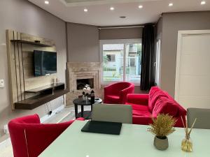 ein Wohnzimmer mit roten Möbeln und einem Kamin in der Unterkunft Casa de Alto Padrão Verdes Campos POA in Porto Alegre