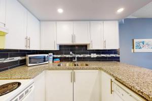 ブルー・マウンテンズにあるCachet Crossing 104の白いキャビネットとシンクのあるキッチン