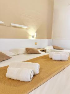 two beds in a room with white pillows on them at Balcone Mediterraneo - Donnalucata & Marina di Ragusa in Ragusa