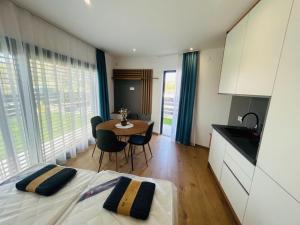 a bedroom with a bed and a table and a kitchen at Cappello Vendégház in Baja