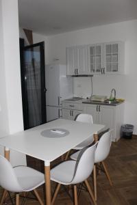a kitchen with a white table and white chairs at AMD - garsonjera 312 in Dobra Voda