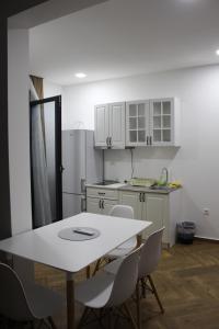 a kitchen with a white table and white cabinets at AMD - garsonjera 312 in Dobra Voda