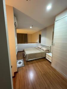 a bedroom with a bed and a wooden floor at Spacious Duplex, Netflix and Various Facilities Pool KL view at i-City Shah Alam in Shah Alam