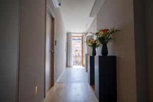 a hallway with two vases with flowers on a dresser at Virginia Madre Boutique Guest House in San Benedetto del Tronto +56 photos