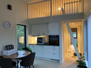 a kitchen with white cabinets and a table with chairs at Moderne minihus in Sula