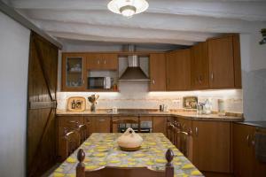 a kitchen with a table with a vase on it at Casa Rural Pilón Azul in Belerdas +57 photos