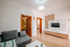 a living room with a couch and a flat screen tv at Villa Yucca in Vlorë