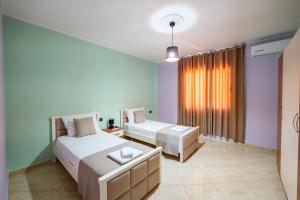 a bedroom with two beds and a window at Villa Yucca in Vlorë