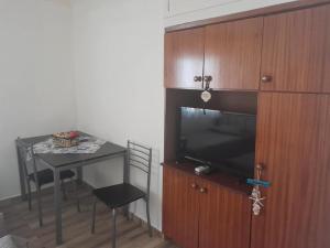 a living room with a table and a flat screen tv at Studio Βασιλική Θανάσης in Nea Michaniona