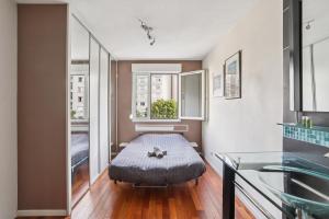 ein kleines Zimmer mit einem Bett und einem Fenster in der Unterkunft Charmant Appartement T2 - Garage in Villeurbanne