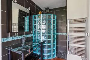 ein Badezimmer mit blauen Glasfliesen und einem Waschbecken in der Unterkunft Charmant Appartement T2 - Garage in Villeurbanne + 6 Fotos