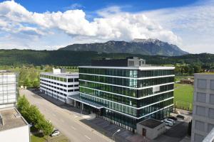 an office building with mountains in the background at Hotel kommod in Ruggell