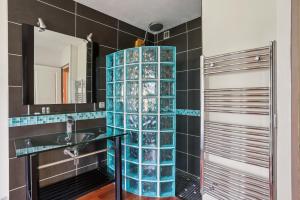 ein Badezimmer mit Waschbecken und blauen Glasregalen in der Unterkunft Charmant Appartement T2 - Garage in Villeurbanne