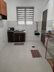 a kitchen with a white tiled floor and a window at NurrCha Homestay Afamosa near WaterparklHondalUniKL in Kampong Pulau Sebang