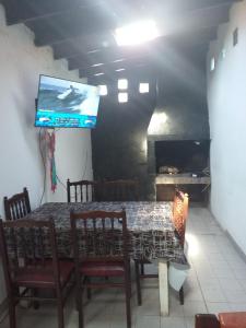 una sala da pranzo con tavolo e TV a schermo piatto di Caisamar Chalet y Relax a Mar del Plata