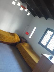 una camera da letto con due letti e una finestra di Caisamar Chalet y Relax a Mar del Plata
