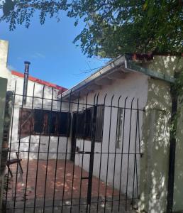 una recinzione di fronte a un edificio bianco di Caisamar Chalet y Relax a Mar del Plata