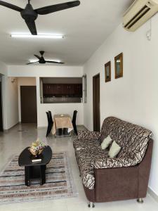 a living room with a couch and a table at NurrCha Homestay Afamosa near WaterparklHondalUniKL in Kampong Pulau Sebang