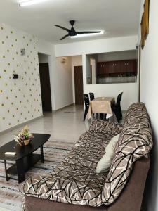 a living room with a bed and a table at NurrCha Homestay Afamosa near WaterparklHondalUniKL in Kampong Pulau Sebang