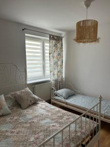 a bedroom with two beds and a window at Wiatrakówka in Kosewo